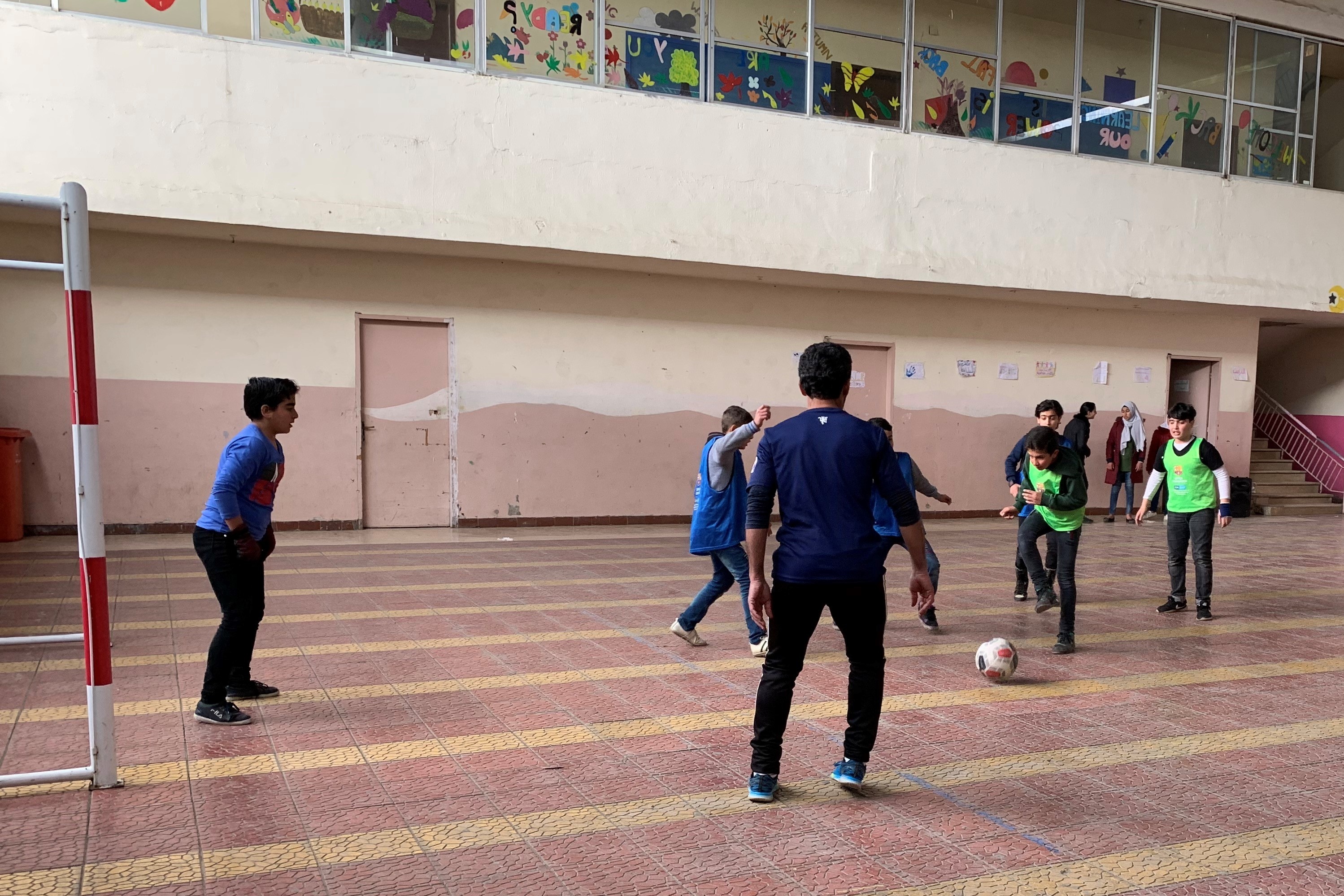 mehrere Jungen spielen Fußball in einer Turnhalle